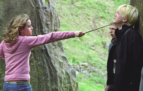 Hermione threatening Draco with her wand in her RIGHT hand
